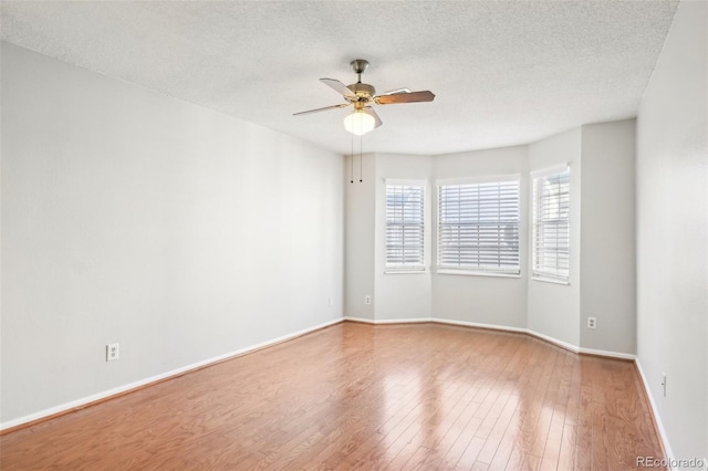 unfurnished room featuring ceiling fan, hardwood / wood-style floors, and a textured ceiling