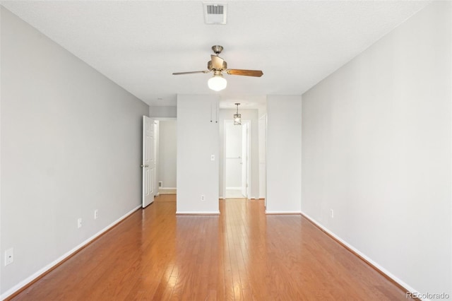 empty room with hardwood / wood-style flooring, a textured ceiling, and ceiling fan