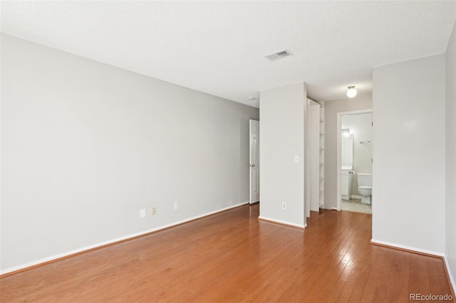 empty room with wood-type flooring and a textured ceiling