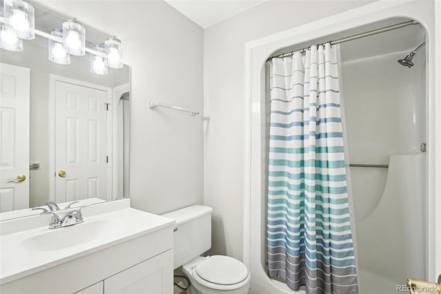 bathroom with toilet, vanity, and a shower with shower curtain