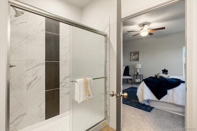 bathroom featuring a shower with shower door and ceiling fan