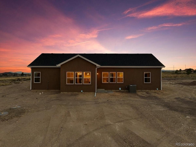 back house at dusk with central air condition unit