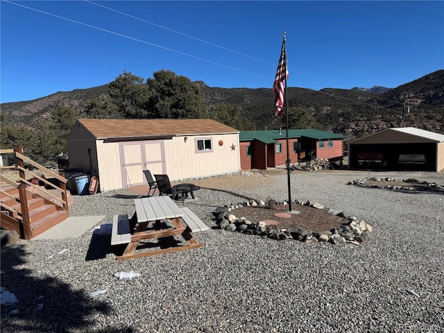 exterior space featuring a carport, a mountain view, and a storage unit