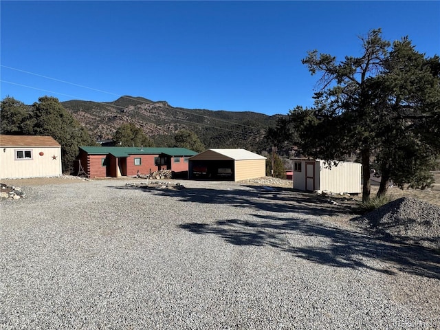 view of front of house with a mountain view and a storage unit