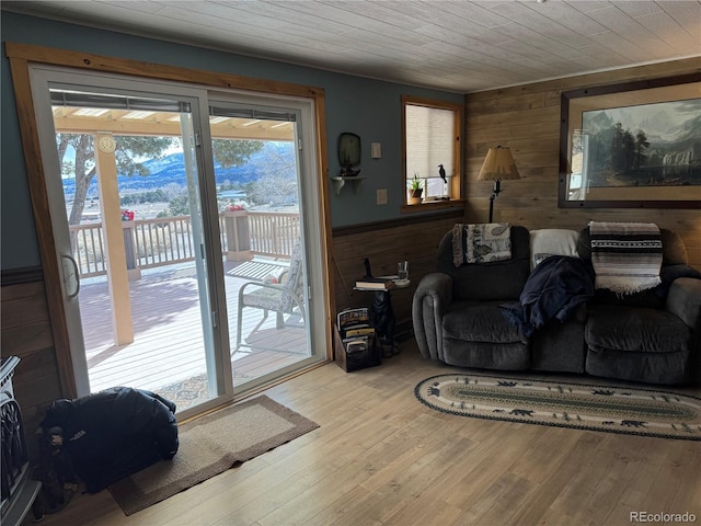 living room with wood walls, wood ceiling, and light hardwood / wood-style floors