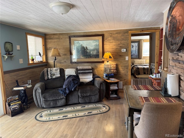 living room featuring wooden ceiling, light wood-type flooring, and wood walls