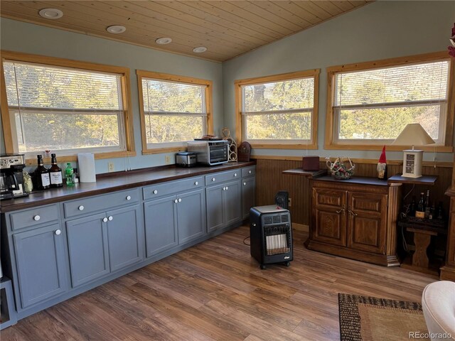 kitchen featuring vaulted ceiling, a healthy amount of sunlight, hardwood / wood-style floors, and wood ceiling