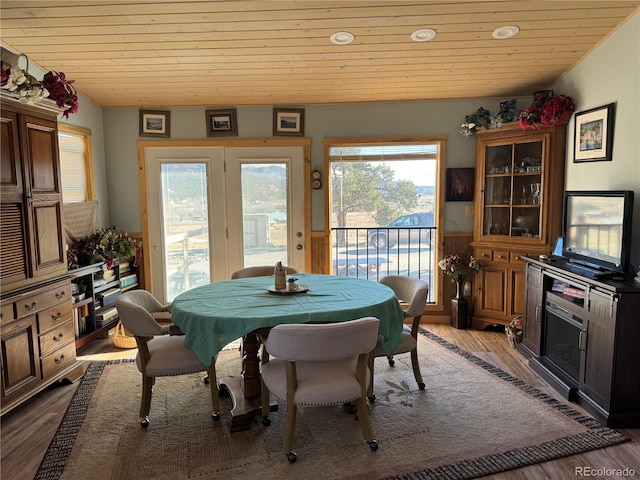 dining room featuring wood ceiling, light hardwood / wood-style flooring, and wood walls