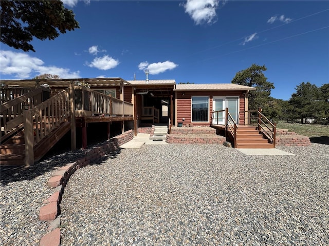 163 Holiday Hills Blvd, Howard, CO 81233 - view of front of home featuring faux log siding, metal roof, a wooden deck, and stairs