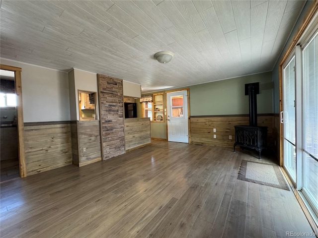 163 Holiday Hills Blvd, Howard, CO 81233 - unfurnished living room featuring a wainscoted wall, a wood stove, wood walls, wood finished floors, and wood ceiling