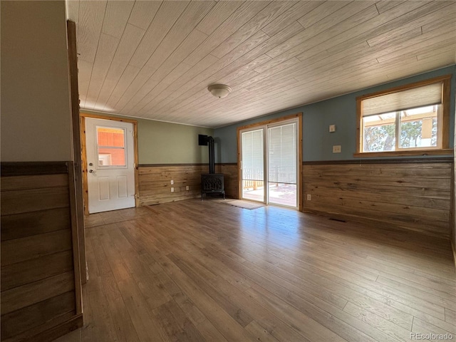 163 Holiday Hills Blvd, Howard, CO 81233 - empty room with wood ceiling, wainscoting, healthy amount of natural light, wooden walls, and a wood stove