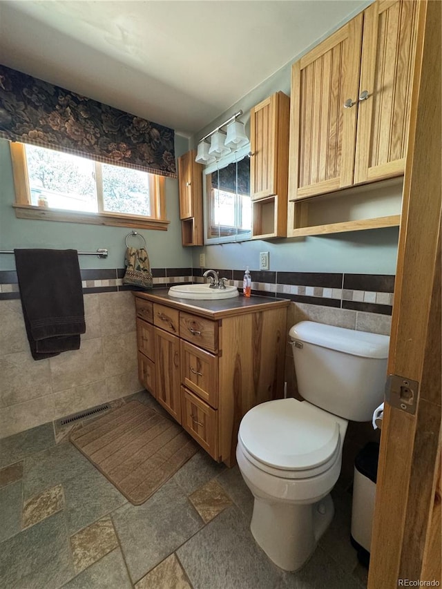 163 Holiday Hills Blvd, Howard, CO 81233 - bathroom featuring tile walls, toilet, vanity, wainscoting, and stone finish flooring