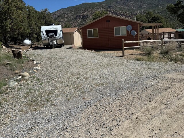 163 Holiday Hills Blvd, Howard, CO 81233 - view of side of property with a mountain view, a shed, an outdoor structure, and fence
