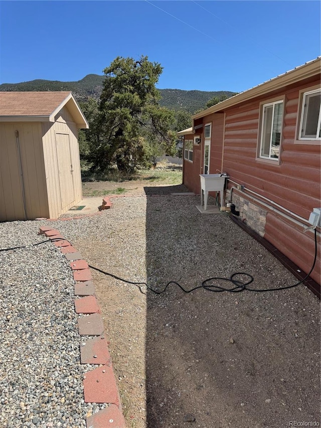 163 Holiday Hills Blvd, Howard, CO 81233 - view of yard with a storage unit, a mountain view, an outdoor structure, and a patio