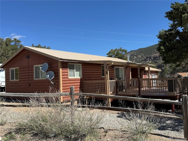 163 Holiday Hills Blvd, Howard, CO 81233 - view of front facade with faux log siding, fence, a deck with mountain view, and metal roof
