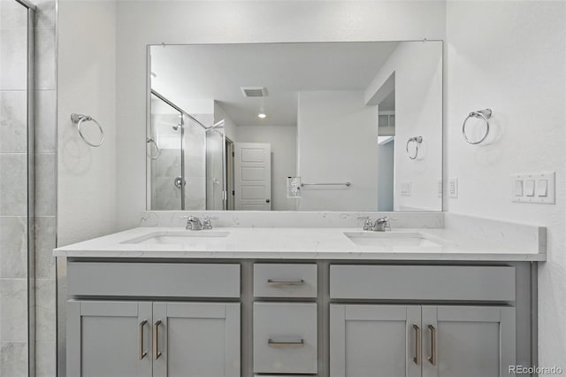 bathroom featuring a shower stall, a sink, visible vents, and double vanity