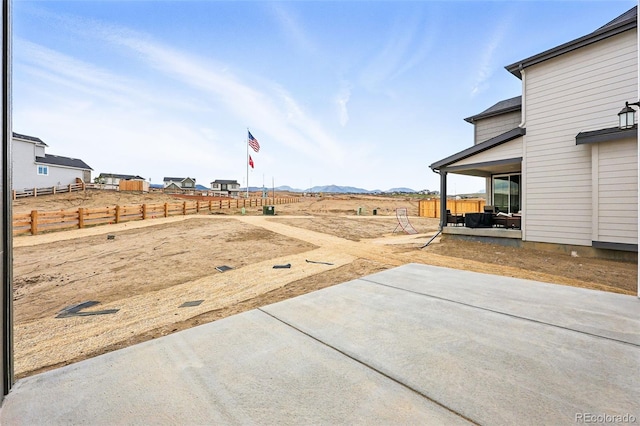 view of yard featuring fence, a patio, and a mountain view