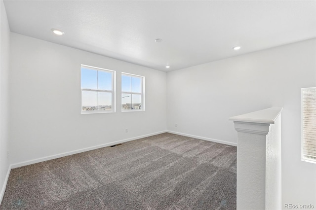 carpeted spare room with visible vents, baseboards, and recessed lighting