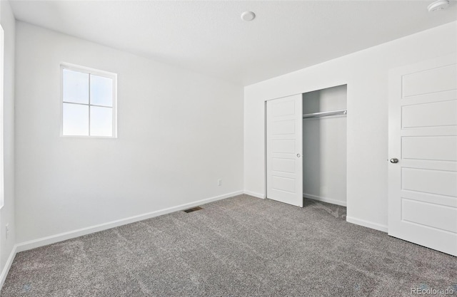 unfurnished bedroom with carpet, a closet, baseboards, and visible vents
