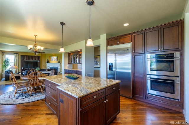 27565 E Nova Pl, Aurora, CO 80016 - kitchen featuring stainless steel appliances, a chandelier, a fireplace, light stone countertops, and dark wood finished floors