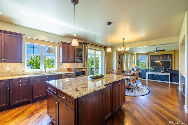 27565 E Nova Pl, Aurora, CO 80016 - kitchen featuring dark wood-type flooring, decorative backsplash, hanging light fixtures, a center island, and a chandelier