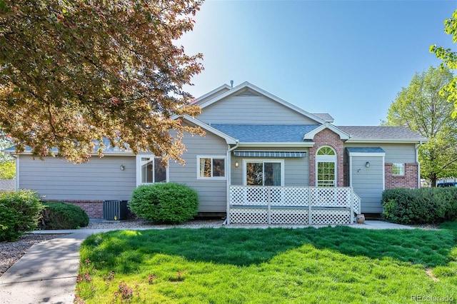 view of front of property featuring a front lawn, a shingled roof, central air condition unit, and brick siding