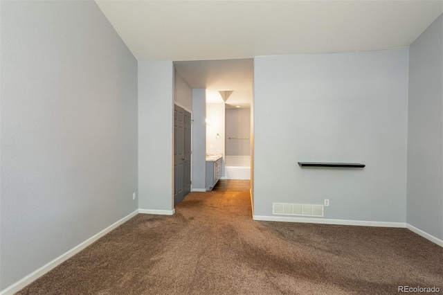 spare room featuring carpet and baseboards