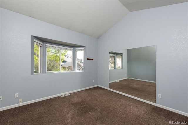 carpeted empty room with lofted ceiling and baseboards