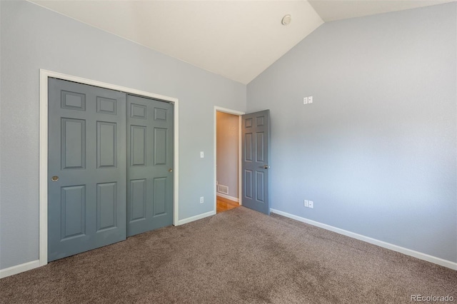 unfurnished bedroom featuring lofted ceiling, carpet, baseboards, and a closet