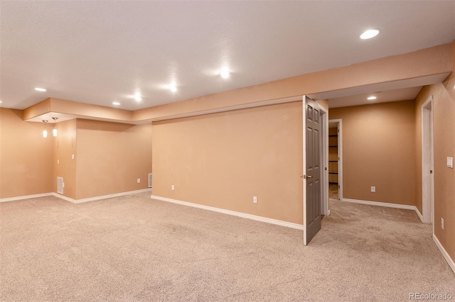 finished basement featuring light carpet, recessed lighting, and baseboards