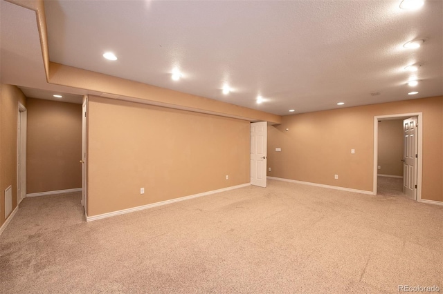 finished below grade area featuring light colored carpet, baseboards, and recessed lighting