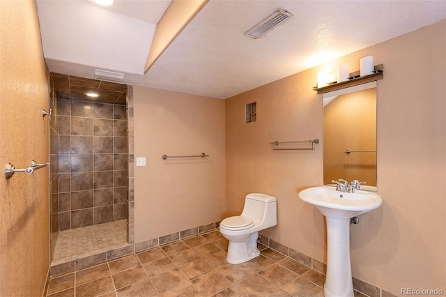 bathroom with walk in shower, toilet, baseboards, and tile patterned flooring