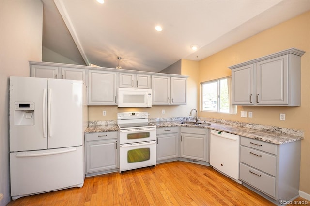 9025 W 79th Way Unit D, Arvada, CO 80005 - kitchen featuring white appliances, light wood-type flooring, vaulted ceiling, light stone counters, and recessed lighting