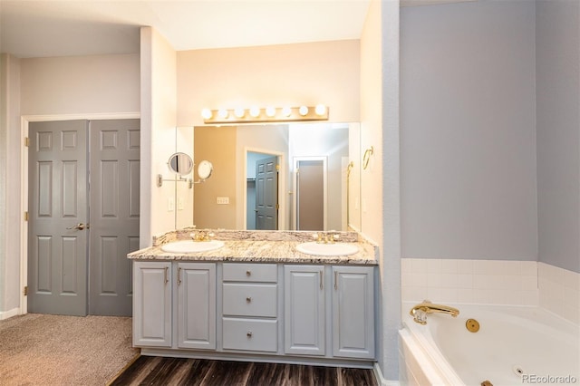 9025 W 79th Way Unit D, Arvada, CO 80005 - bathroom with double vanity, a jetted tub, and wood finished floors