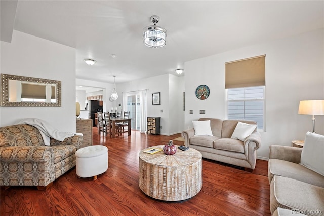 living room featuring dark wood-type flooring and an inviting chandelier