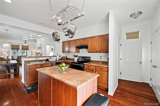 kitchen featuring dark wood-type flooring, electric range, sink, and pendant lighting