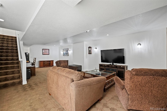 carpeted living room featuring a textured ceiling