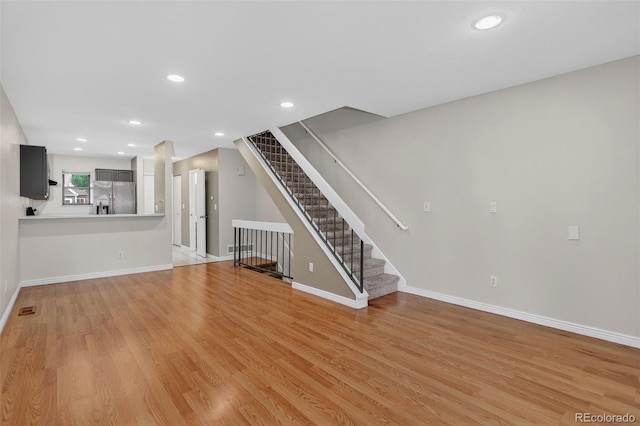 7474 E Arkansas Ave Unit 18-10, Denver, CO 80231 - unfurnished living room featuring light wood finished floors, stairway, and recessed lighting