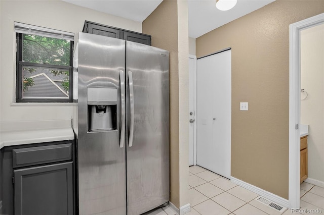 7474 E Arkansas Ave Unit 18-10, Denver, CO 80231 - kitchen featuring stainless steel fridge, light countertops, light tile patterned floors, and gray cabinets