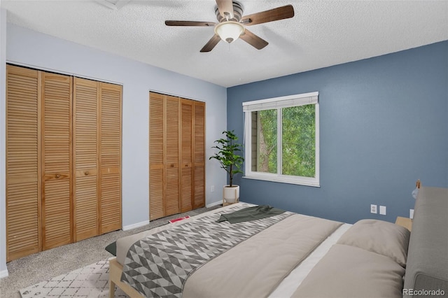 7474 E Arkansas Ave Unit 18-10, Denver, CO 80231 - bedroom with two closets, a textured ceiling, and a ceiling fan