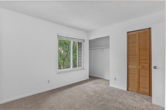 7474 E Arkansas Ave Unit 18-10, Denver, CO 80231 - unfurnished bedroom with multiple closets, carpet floors, and a textured ceiling