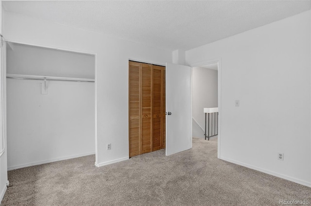 7474 E Arkansas Ave Unit 18-10, Denver, CO 80231 - unfurnished bedroom featuring two closets, carpet, and a textured ceiling