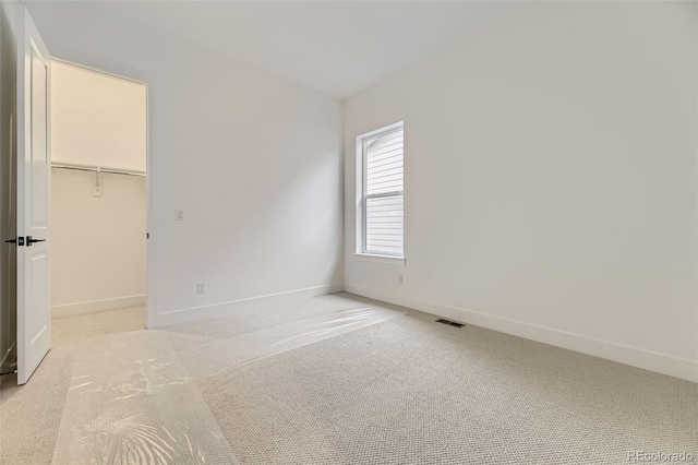 231 Leafy Aster Ln, Castle Rock, CO 80104 - unfurnished bedroom with baseboards, light colored carpet, a walk in closet, and a closet