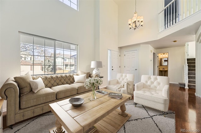 living room with hardwood / wood-style floors, plenty of natural light, a high ceiling, and a chandelier