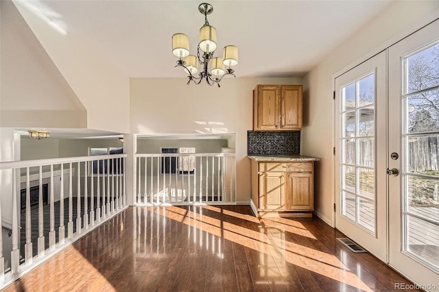 interior space with decorative backsplash, dark hardwood / wood-style flooring, a chandelier, and french doors