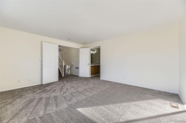 unfurnished bedroom featuring carpet floors and ensuite bathroom