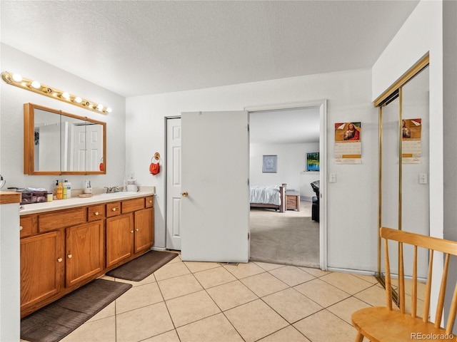4906 Perth St, Denver, CO 80249 - full bath featuring double vanity, tile patterned floors, ensuite bathroom, and a textured ceiling