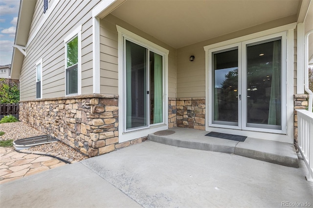6520 S Newcastle Way, Aurora, CO 80016 - view of exterior entry with stone siding and a patio area