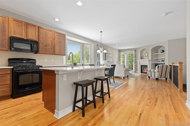 6520 S Newcastle Way, Aurora, CO 80016 - kitchen featuring black appliances, healthy amount of natural light, light wood-style floors, light countertops, and recessed lighting