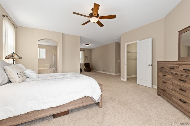 6520 S Newcastle Way, Aurora, CO 80016 - bedroom with arched walkways, light colored carpet, connected bathroom, and baseboards